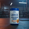 Applied Nutrition Carb-X Cyclic Dextrin powder container on a gym floor