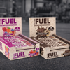 Boxes of Fuel high protein snack bars on a gym background