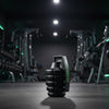 Black gym roller with green branding in a dark gym setting