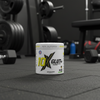 10X Glut+ supplement container on a gym floor with weights and exercise equipment in the background