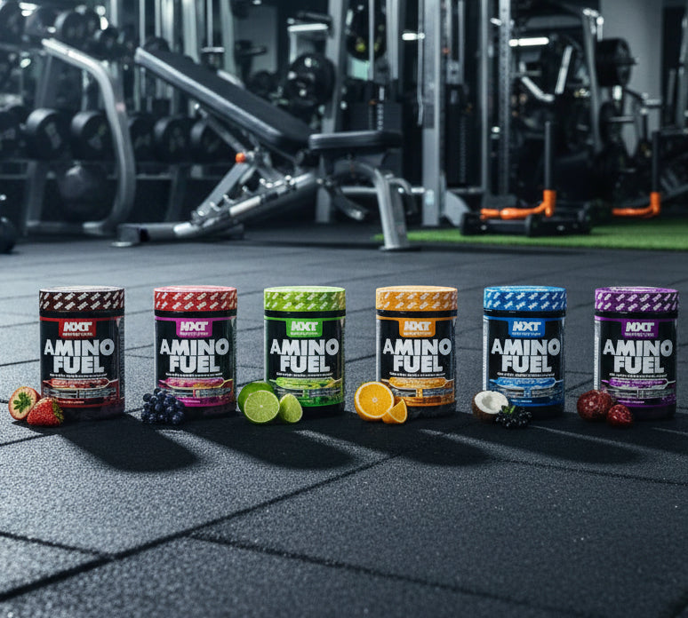 Row of Amino Fuel supplement containers on a gym floor with gym equipment in the background.
