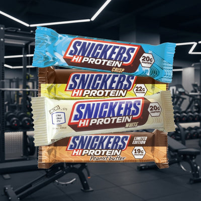Four Snickers Hi Protein bars in different flavors against a gym background
