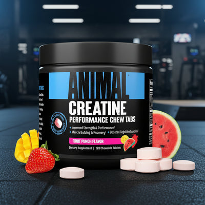 Container of Animal Creatine Performance Chew Tabs with fruit on a gym floor background
