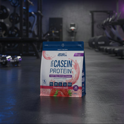 Package of Applied Nutrition 100% Casein Protein in Strawberry Cream flavour on a gym background